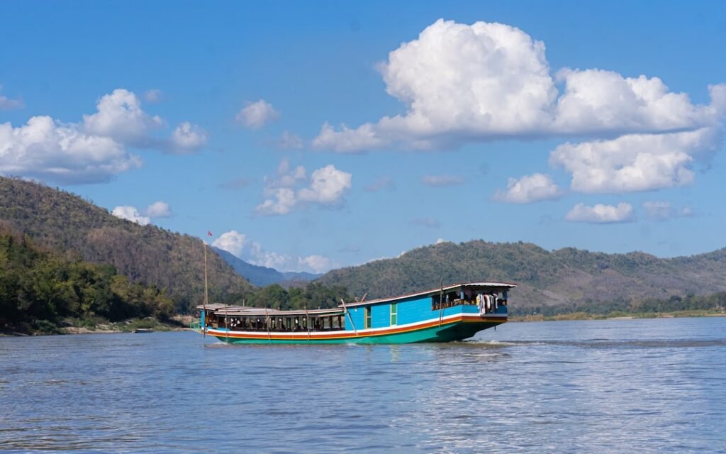 a blue and white boat floating on top of a lake