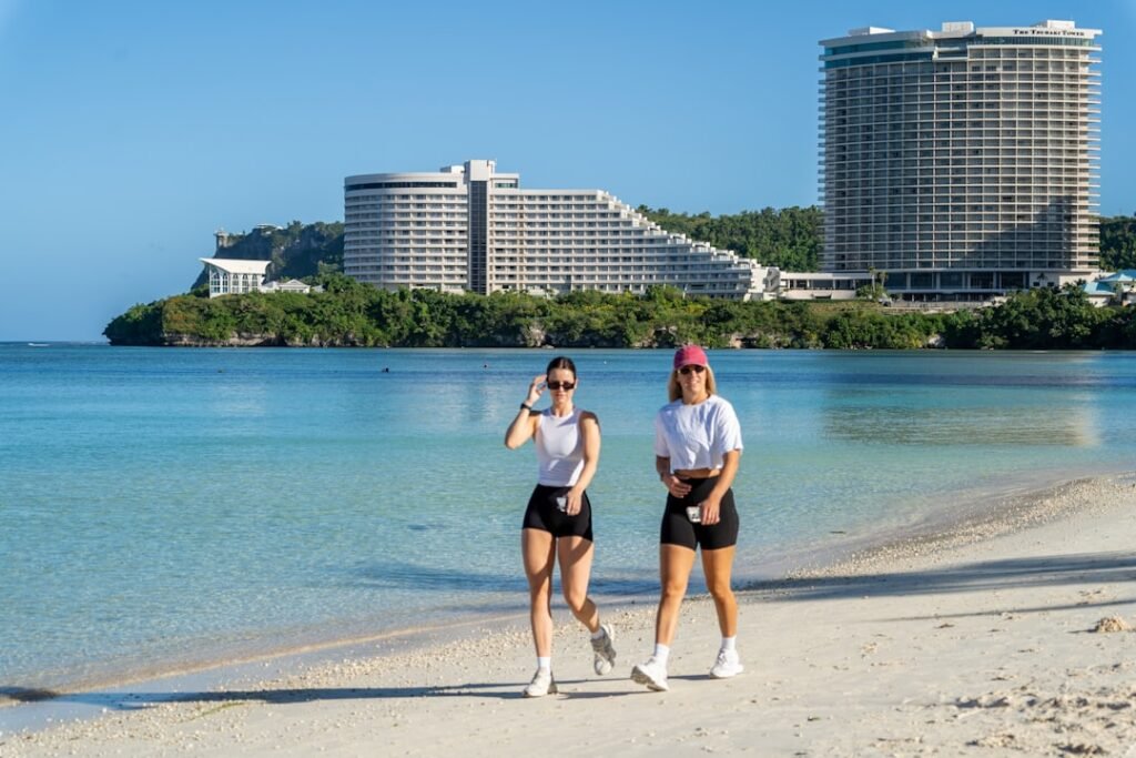A couple of people that are standing in the sand