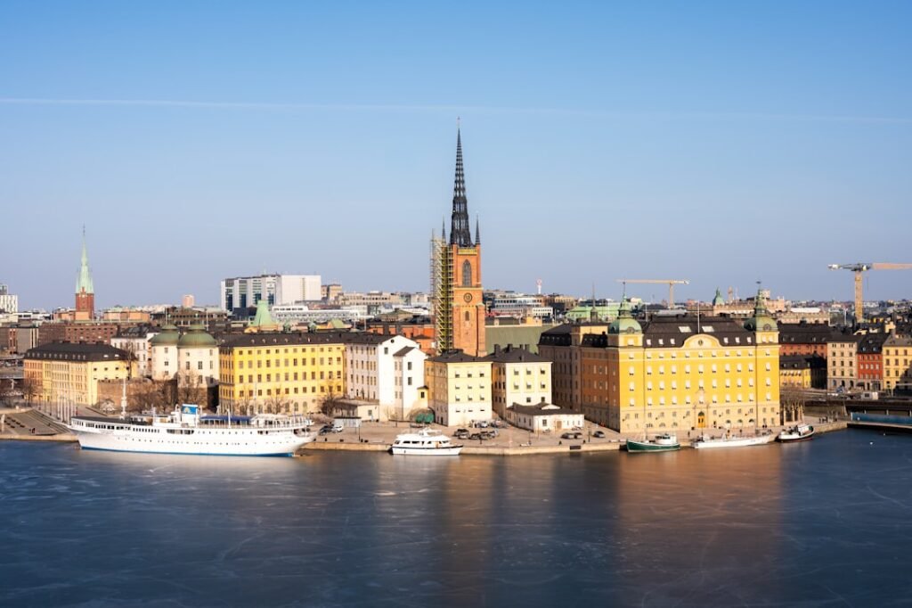 City skyline with historic buildings and a large white ship.