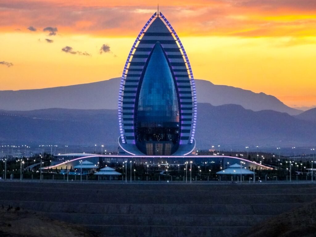 Modern building illuminated at sunset with mountains background